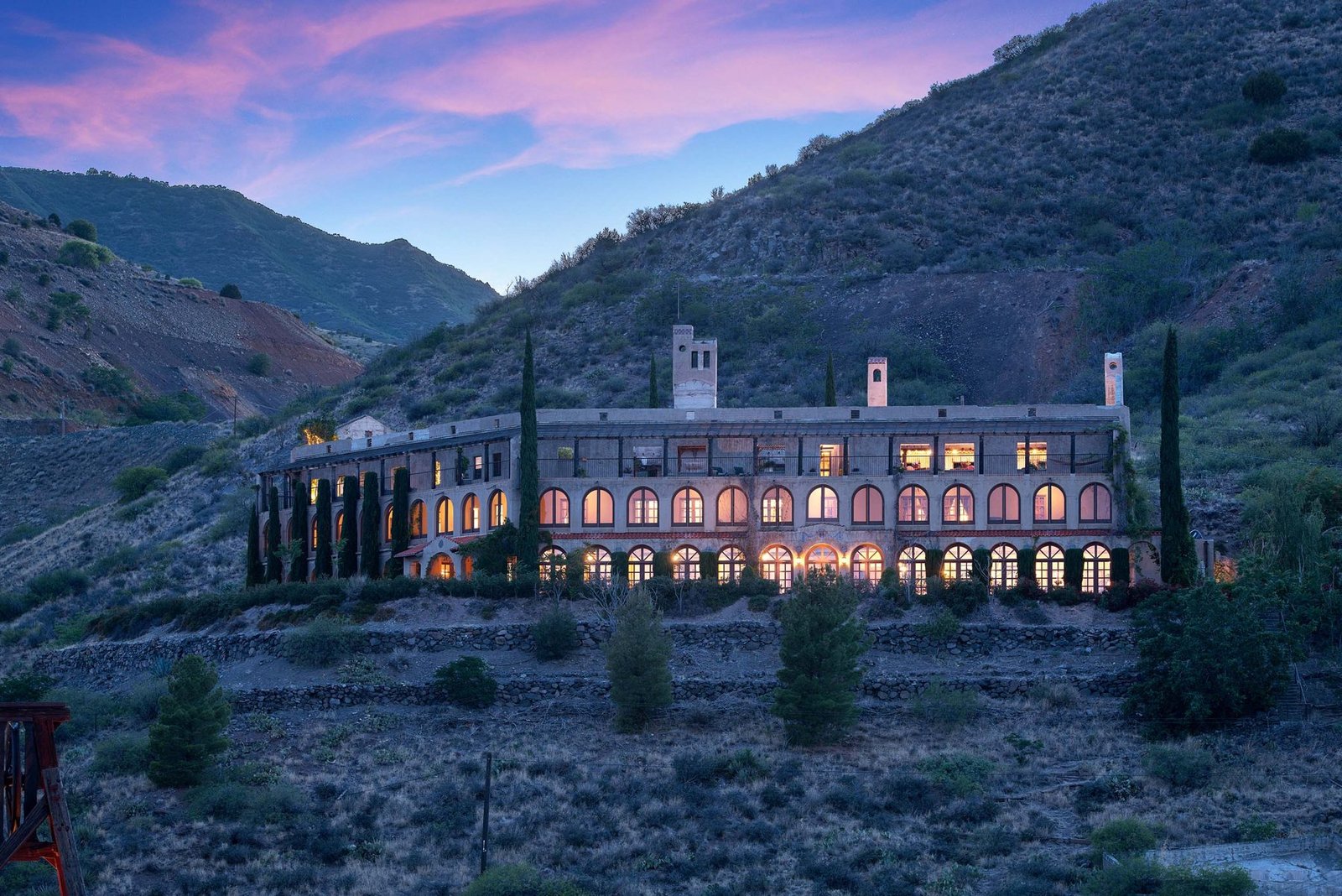The Little Daisy, a wedding venue in Jerome, Arizona, lit up at dusk on the hillside