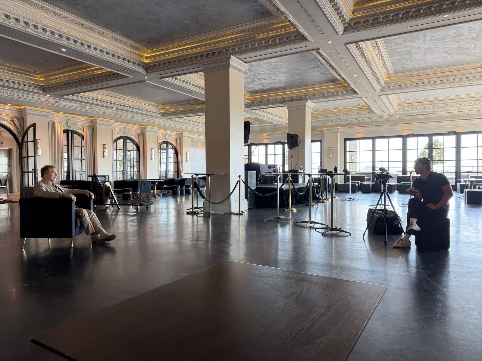 Filming a founder interview in an ornate ballroom with a gold ceiling during a wedding venue content shoot